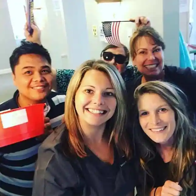 Doctor and staff in the office smiling together