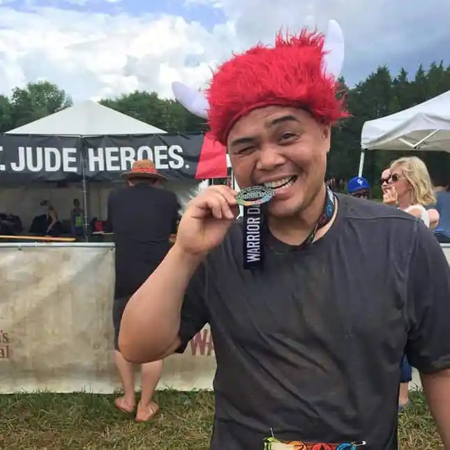 Doctor biting a medal he's won in a charity race for st jude hospital