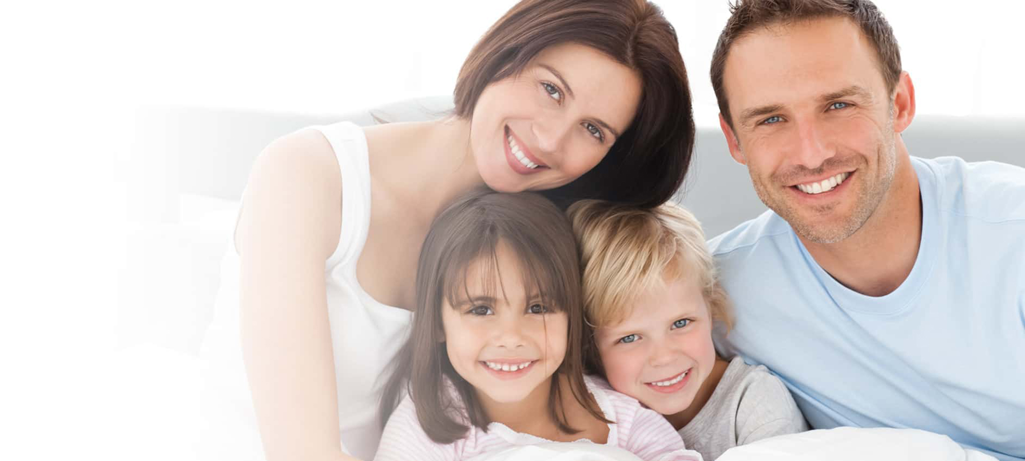 Family of four smiling at the camera