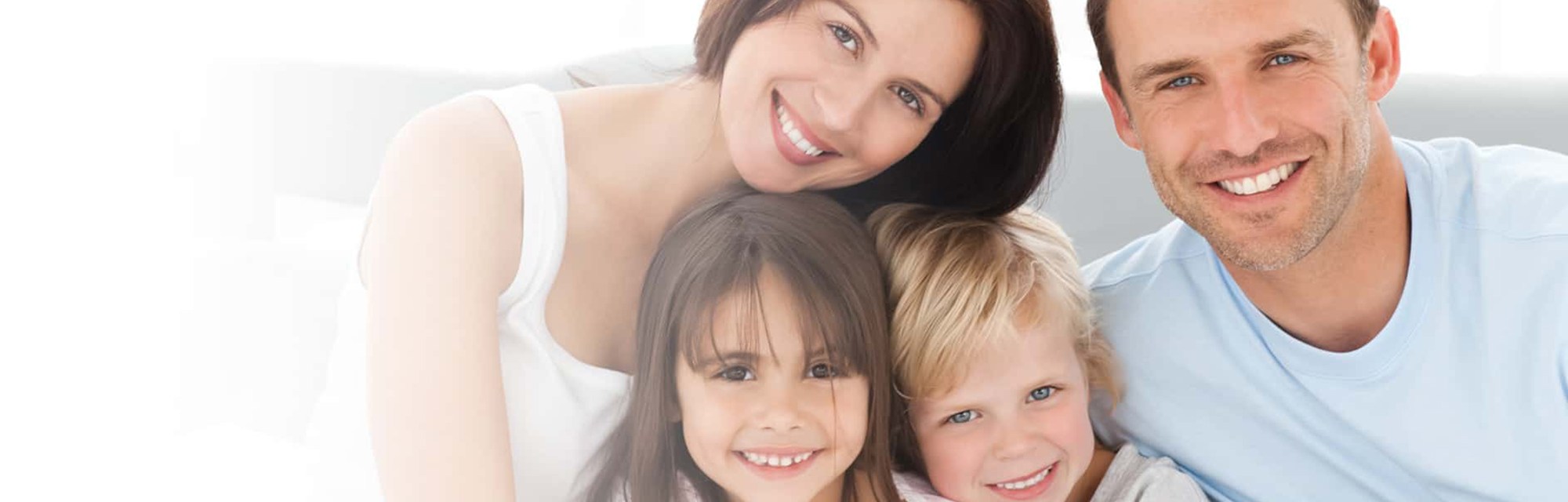 Family of four smiling at the camera
